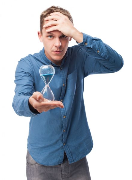 Man holding hourglass with hand at his head